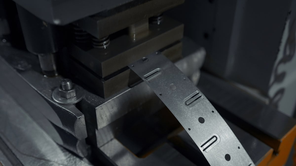 A large industrial punch press forming sheet metal parts.