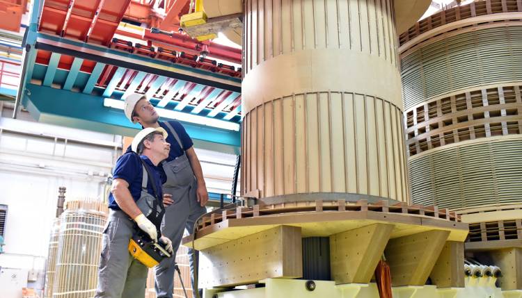 two men looking at large b2b manufacturing product on lift