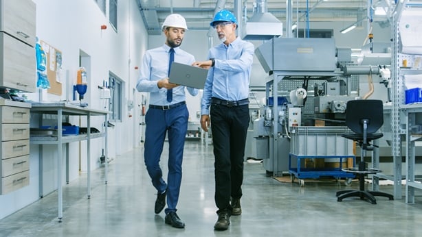 two workers discussing supply chain shortages.