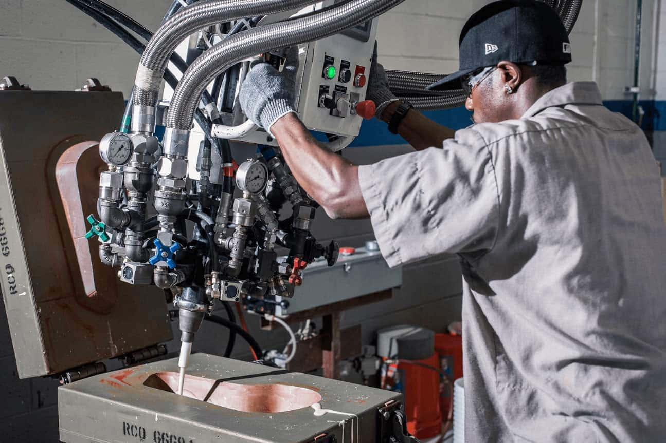 A man working on a molded foam machine