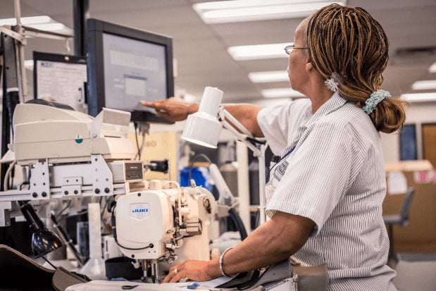 A woman checking over a machine for a automotive interiors supplier