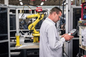 A worker operates the computer controlling one of RCO's robotic welding units. 