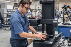 A worker operates a machine to manufature aerospace components. 