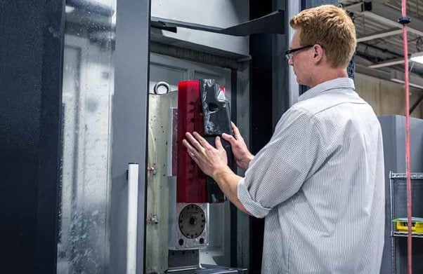 A man starting a cnc machining services machine