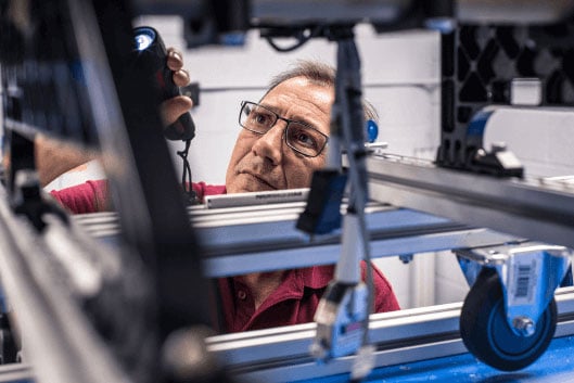 A worker verifies the quality and accuracy of an aerospace seat. A worker verifies the quality and accuracy of an aerospace seat.