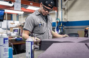Man finishing foam product after custom foam molding at RCO Engineering