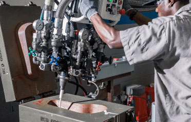 A worker operates a molded foam machine at RCO engineering made by aerospace manufacturing services