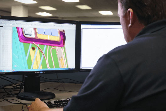 A designer from a contract manufacturing engineering services company reviewing CAD data for a production aerospace seat.