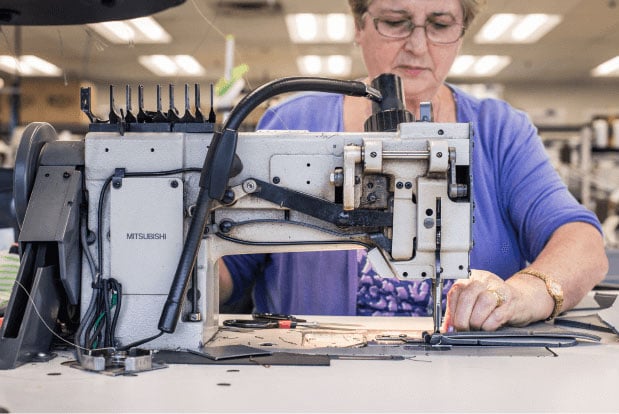 A woman sewing for a automotive interiors supplier